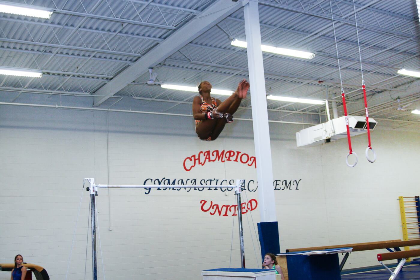 Gymnast in the air above the uneven bars